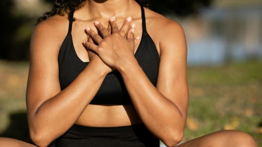 Person practicing deep breathing outdoors to illustrate how stress messes with blood sugar.